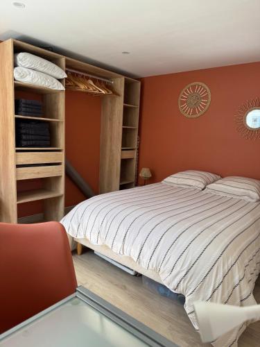 a bedroom with a large bed and a chair at appartement 4 personnes yvetot maurienne express in Saint-Jean-de-Maurienne
