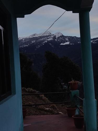 a view of a snow covered mountain from a house at Nanda Devi Home Stay in Sari