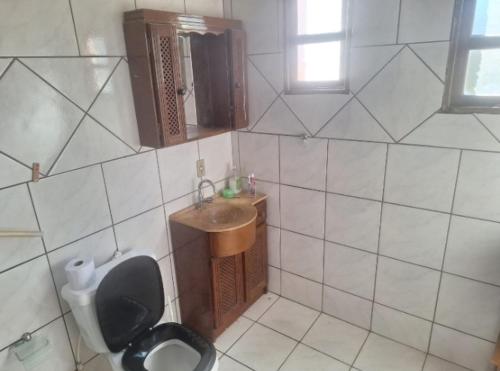 a small bathroom with a toilet and a sink at Casa simples com 02 quartos para Oktoberfest in Blumenau