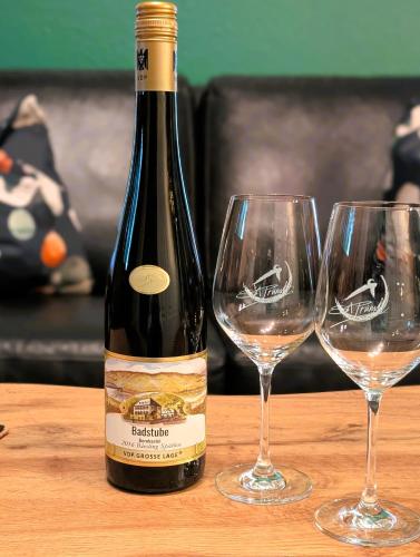 a bottle of wine sitting next to two wine glasses at Wein- und Landhaus S A Prüm in Bernkastel-Kues