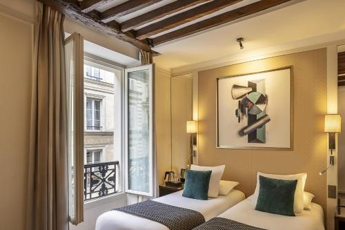 two beds in a room with a window at Best Western Plus Hotel Sydney Opera in Paris