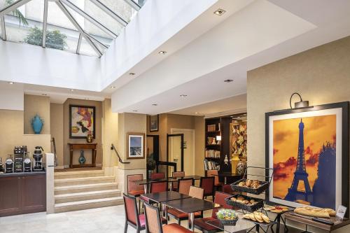 a living room with a table and chairs at Best Western Plus Hotel Sydney Opera in Paris