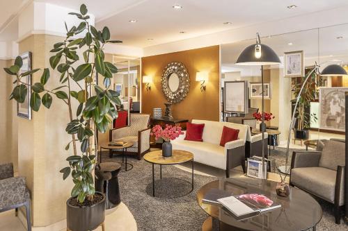 a living room with a couch and a table at Best Western Plus Hotel Sydney Opera in Paris