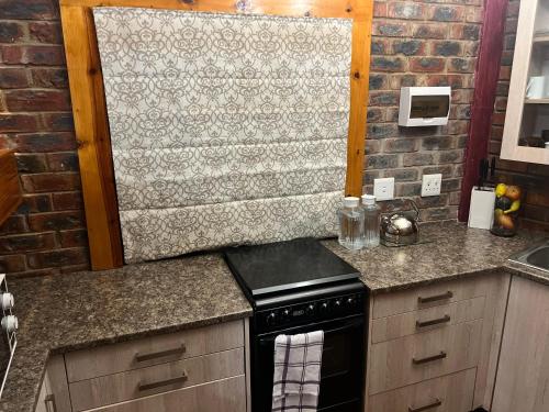 a kitchen with a stove and a counter top at Sanchen's in Clarens