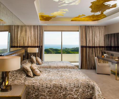 a hotel room with a bed and large windows at Rixos Premium Belek - The Land of Legends Access in Belek