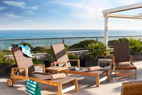 a patio with chairs and a table and the ocean at Rixos Premium Belek - The Land of Legends Access in Belek