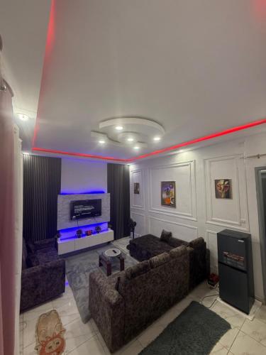 a living room with two couches and a tv at Bon séjour in Bouaké