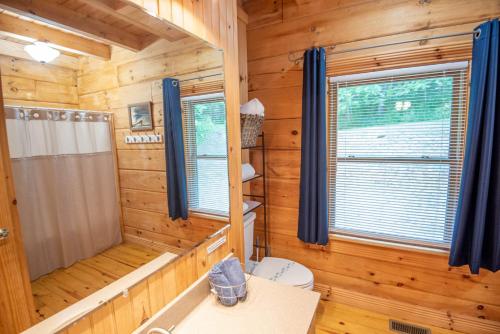 a log cabin bathroom with a shower and a toilet at Updated Cabin Mins from Downtown West Jefferson- Hot Tub, Porches, Dogs OK in West Jefferson