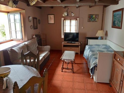a living room with a couch and a tv at Casa De la Agüera in Busto