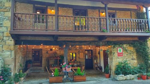 a building with a balcony and tables and plants at Posada La Dalia in Castillo-Pedroso