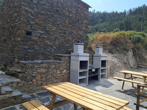 a wooden bench sitting next to a brick wall at AL Rossadas Margurisse in Benfeita