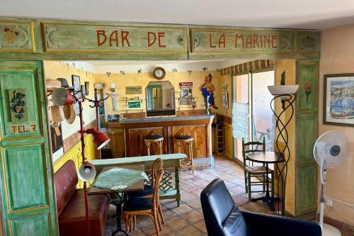 Un bar en un restaurante con un cartel en la pared. en Spacious & Unique Sea View Apt Terrace Pool & Charm, en Le Lavandou