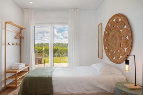 a bedroom with a bed and a large window at Casa da Vinha in Óbidos