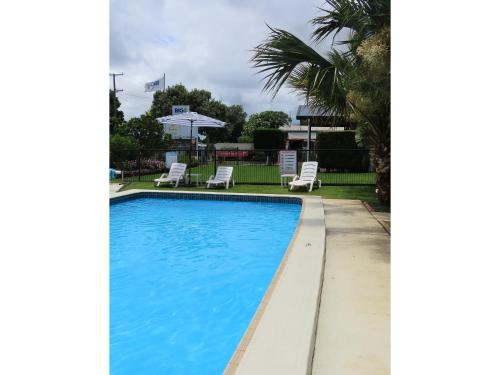 a swimming pool with two lounge chairs next to it at BIG4 Toowoomba Garden City Holiday Park in Toowoomba