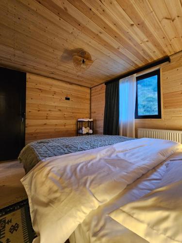 (( Gergeti ))Gergeti Twins - Cottages的一张位于带木制天花板的客房内的大床