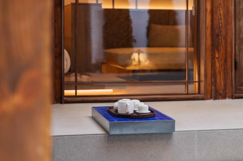 a plate with three white cups on a bluevisor at Luxury Hanok Stay Blue Dot in Seoul