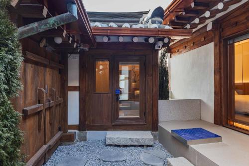 an entrance to a house with a wooden door at Luxury Hanok Stay Blue Dot in Seoul