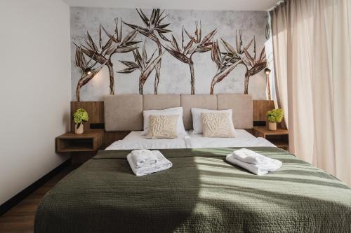a bedroom with a large bed with two towels on it at Apartamenty Na Stawach 24 in Stary Sącz
