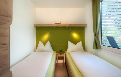 two beds in a room with a window at Ferienparadies Natterer See in Innsbruck