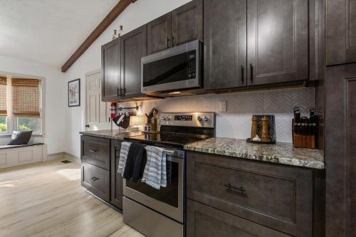 a kitchen with wooden cabinets and a stove top oven at Bourbon Trail-Speakeasy&Golf&Spa&Dog Friendly in Frankfort