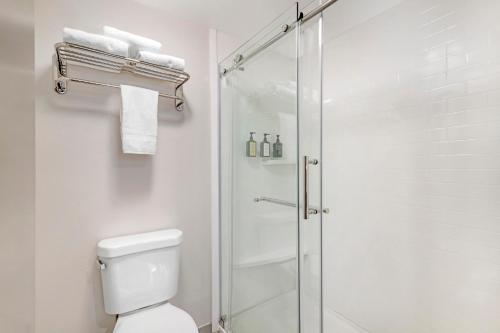 a white bathroom with a shower and a toilet at Keene Elm City Hotel, an Ascend Collection Hotel in Keene