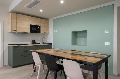 a kitchen with a wooden table and white chairs at Front Lake Como - 3 Bedrms with AC, Free Parking and Wifi in Olginate