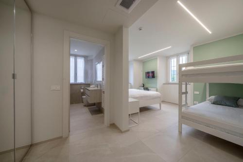 a bedroom with two bunk beds and a bathroom at Front Lake Como - 3 Bedrms with AC, Free Parking and Wifi in Olginate