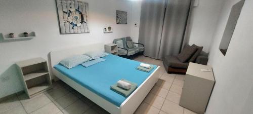 a small bedroom with a bed and a chair at Magic Sea Apartments in Larnaka