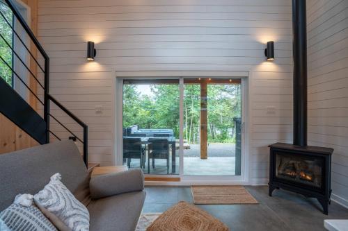 una sala de estar con chimenea en una casa en Spa et River - Le Grand-Pic, en Saint-Alexis-des-Monts