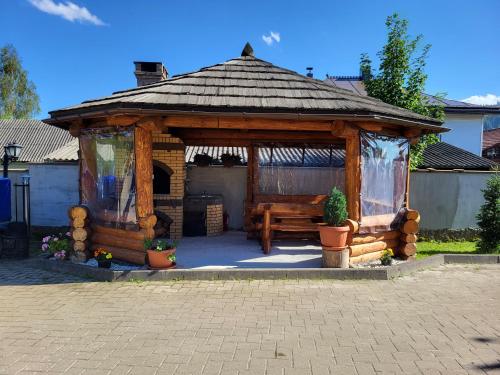 a wooden gazebo with a bench in a yard at Casa Andreea in Vatra Dornei