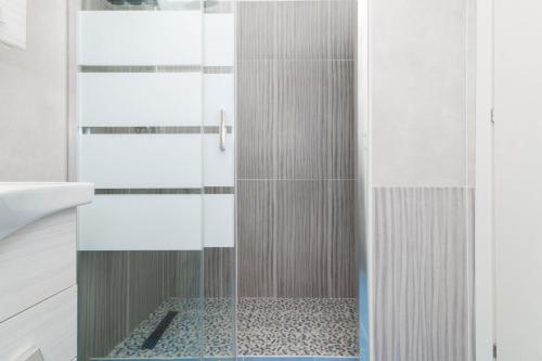 a shower with a glass door in a bathroom at Molino Lounge Express 20' da Milano e Malpensa in Saronno