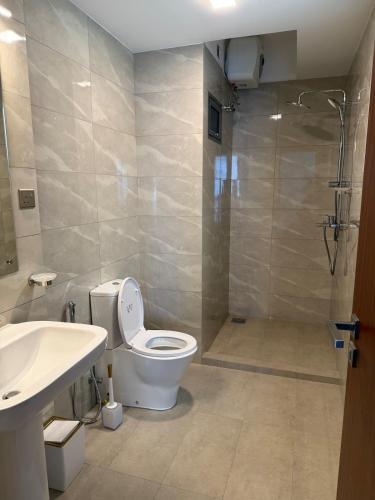a bathroom with a toilet and a sink and a shower at Marina Luxe Appartment in Dehiwala