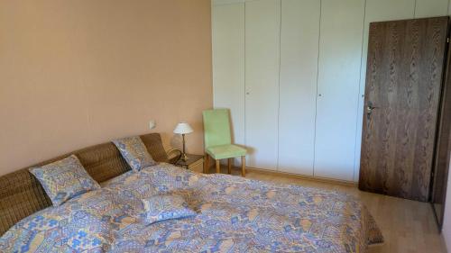 a bedroom with a bed and a green chair at Ferienwohnung Bei Grüns - nur Urlaubsgäste in Konz
