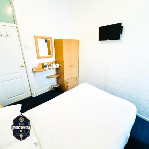 a small room with a bed and a mirror at The Sandhurst Hotel in Blackpool