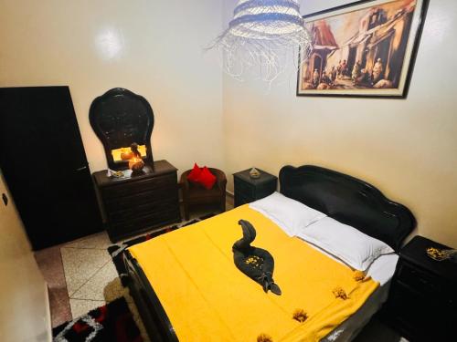 a bedroom with a bed with a black bird on it at Tigme Bleue Wave in Tama ou Ennza