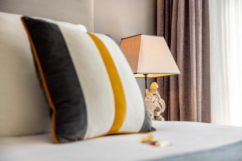 a bed with two pillows and a lamp on it at Jupiter Hotel in Amsterdam