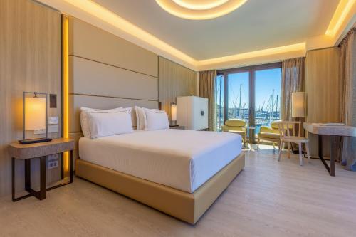 a hotel room with a bed and a table and chairs at Porto Lotti Suite Hotel in La Spezia