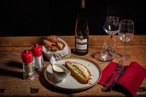 a table with a plate of food and a bottle of wine at Europe Haguenau – Hotel & Spa in Haguenau