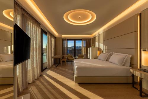a hotel room with a bed and a television at Porto Lotti Suite Hotel in La Spezia