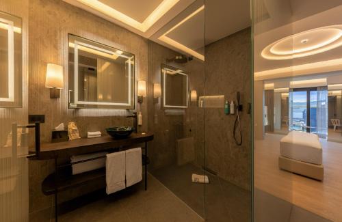 a bathroom with a shower and a sink and a mirror at Porto Lotti Suite Hotel in La Spezia