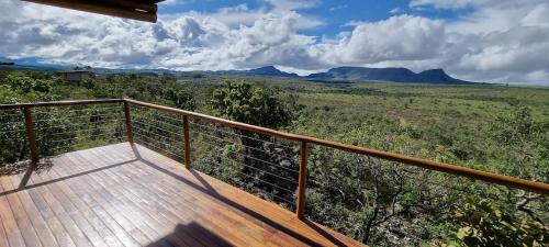 a wooden balcony with a view of the mountains at Chalé Canela de Ema in Sao Jorge
