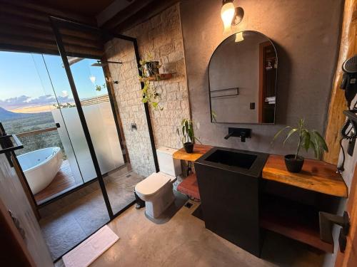 a bathroom with a tub and a toilet and a sink at Chalé Canela de Ema in Sao Jorge