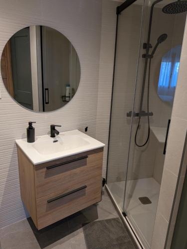 a bathroom with a sink and a shower with a mirror at Apartamento Gandiaport in Gandía