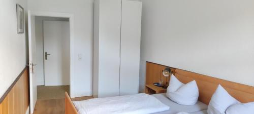 a bedroom with a bed with white sheets and pillows at Hotel Zur Fähre in Boppard
