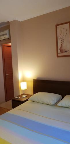 a bedroom with a bed and a lamp on a table at GrandVille Apartments in Bucharest