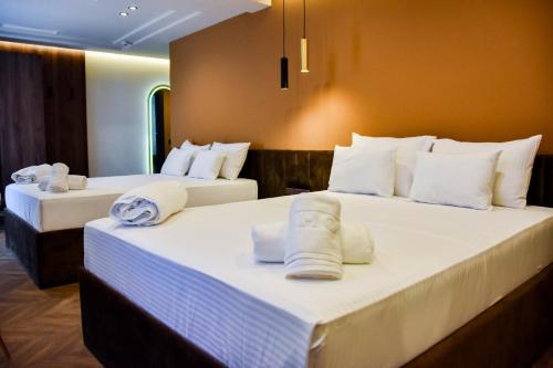 two beds in a hotel room with towels on them at Spa&Hotel Studenac in Trebinje