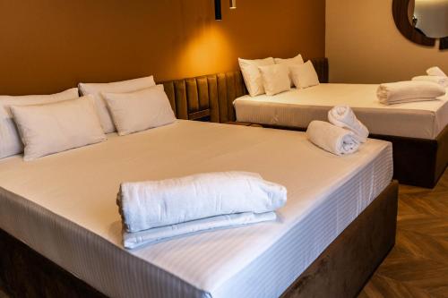 two beds in a room with towels on them at Spa&Hotel Studenac in Trebinje