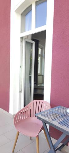 a pink chair and a table in front of a building at Hotel Zur Fähre in Boppard