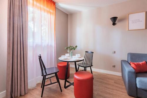 a living room with a table and chairs and a couch at Appart'City Confort Montpellier Saint Roch in Montpellier