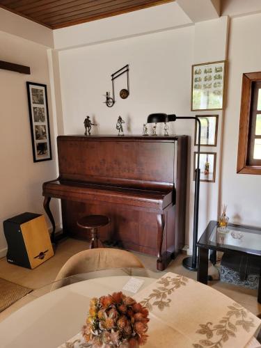 un pianoforte in un soggiorno con un tavolo e una lampada di Invernada Blessmann - quarto 1 a Vespasiano Corrêa